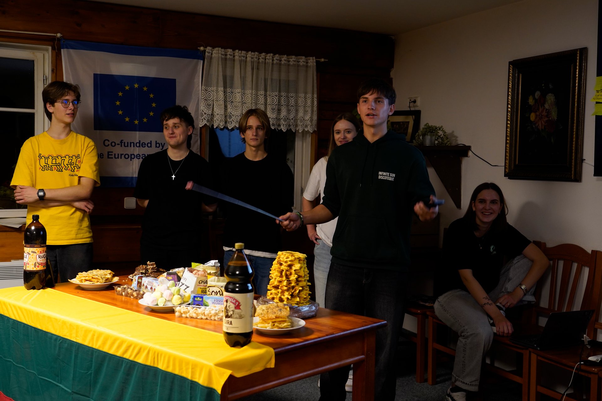 The table set with šakotis, gira and food from home
