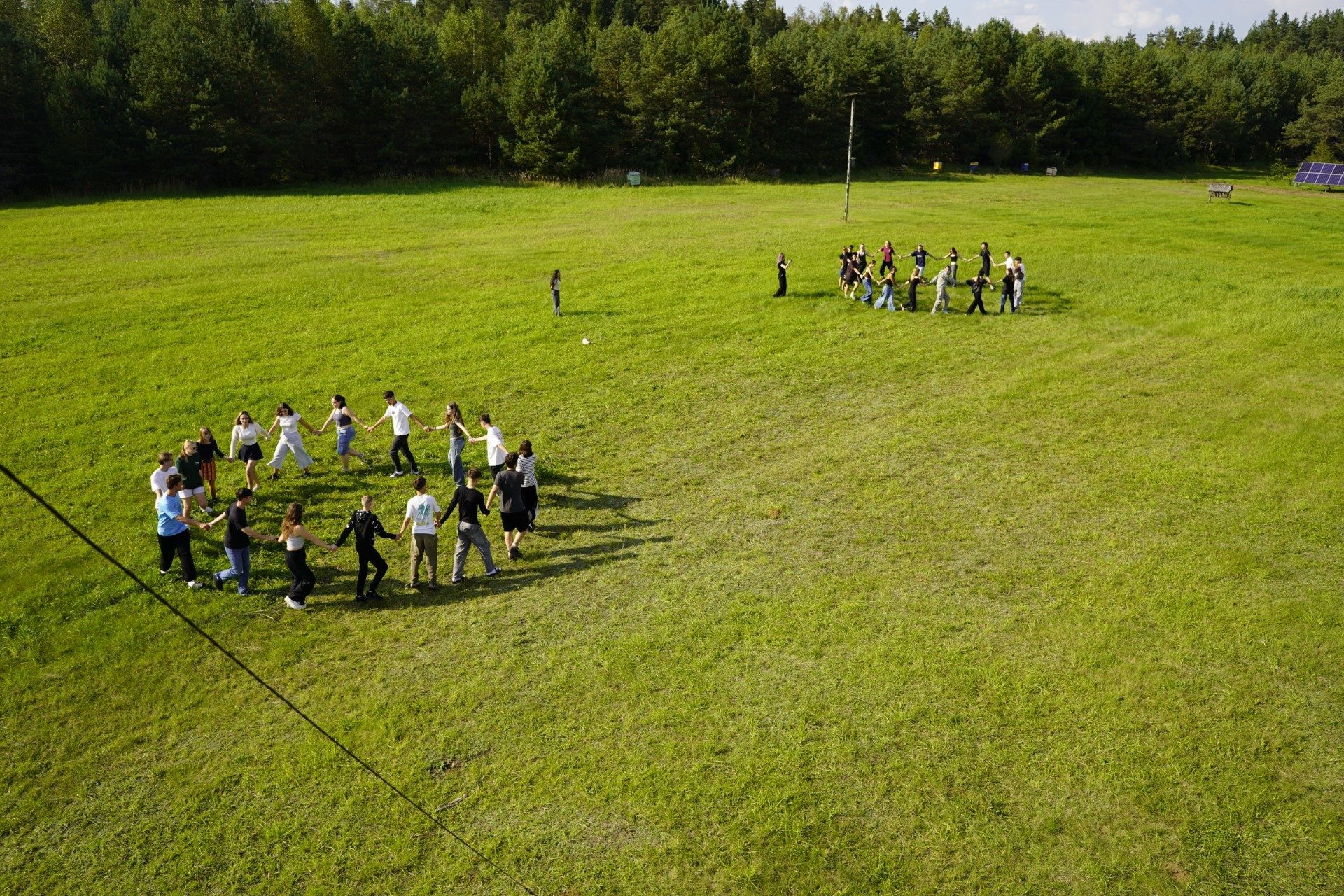 The whole group forms a circle in the field