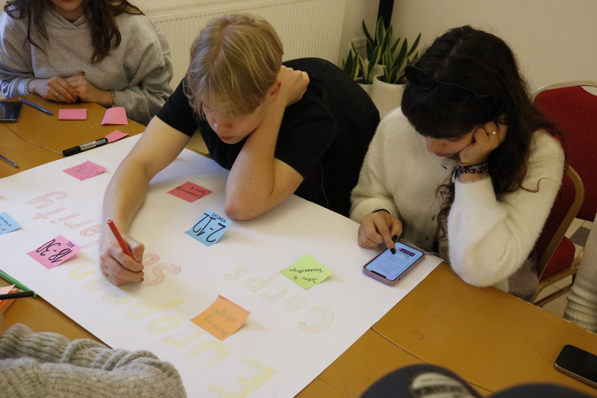 A team designing their poster at a table